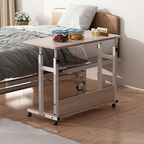 Woman using adjustable overbed table with laptop and coffee mug while in bed