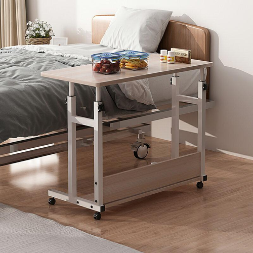 Woman using adjustable overbed table with laptop and coffee mug while in bed