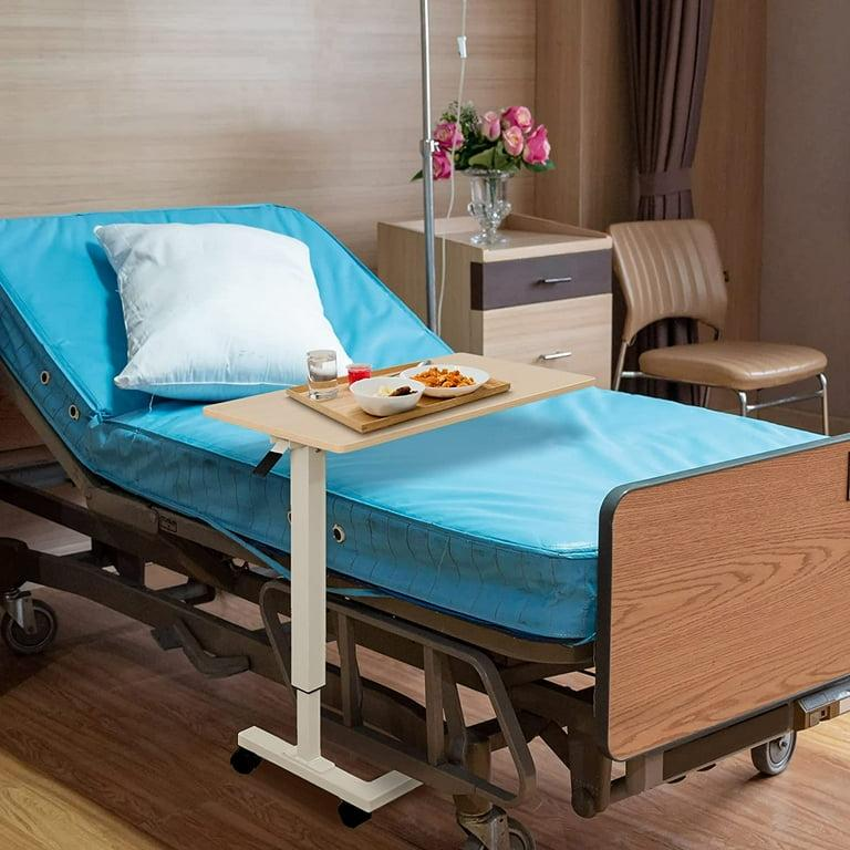 White electric adjustable overbed table next to upholstered bed in modern bedroom