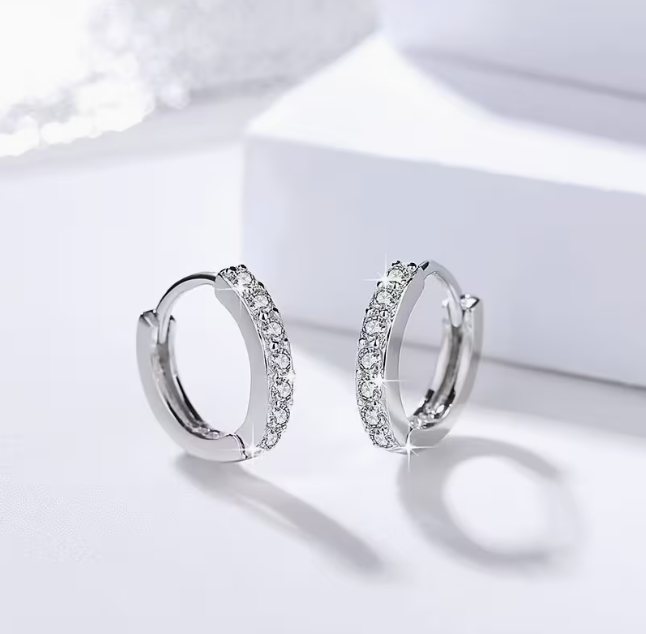 Lumière Pavé Huggie Hoop Earrings – worn on ear, close-up lifestyle shot