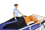 Nurse repositioning elderly patient in bed using turning aid
