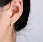 Lumière Pavé Huggie Hoop Earrings – silver pavé hoops on grey textured surface