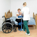 Caregiver fitting patient turning aid on elderly woman in bed