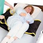 Patient turning aid with yellow handles used to reposition elderly woman in bed